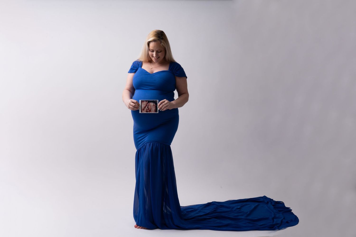 A series of four fashion poses featuring a model in a flowing navy blue evening gown against a light backdrop.