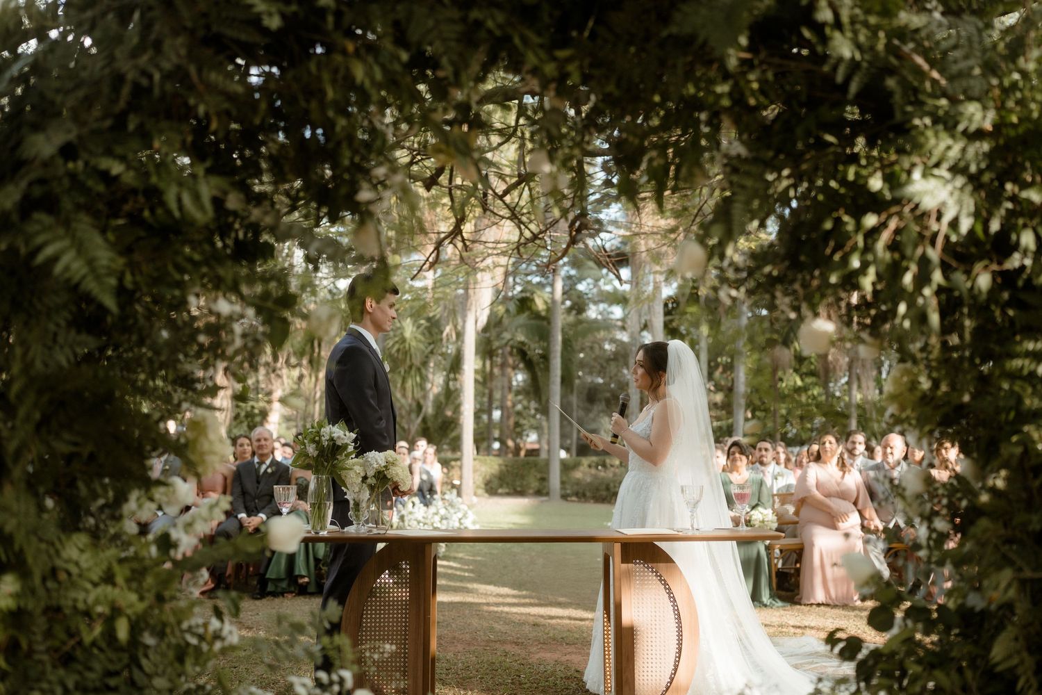 Sunlit garden path with lush trees creating natural archways.