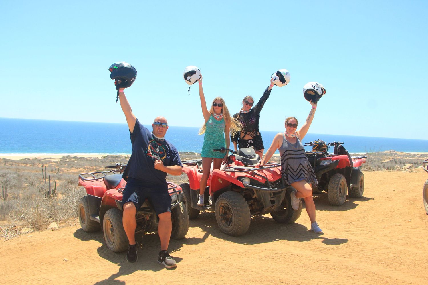 A sequence of ATV riders taking photos at scenic desert overlook points against a bright blue sky.