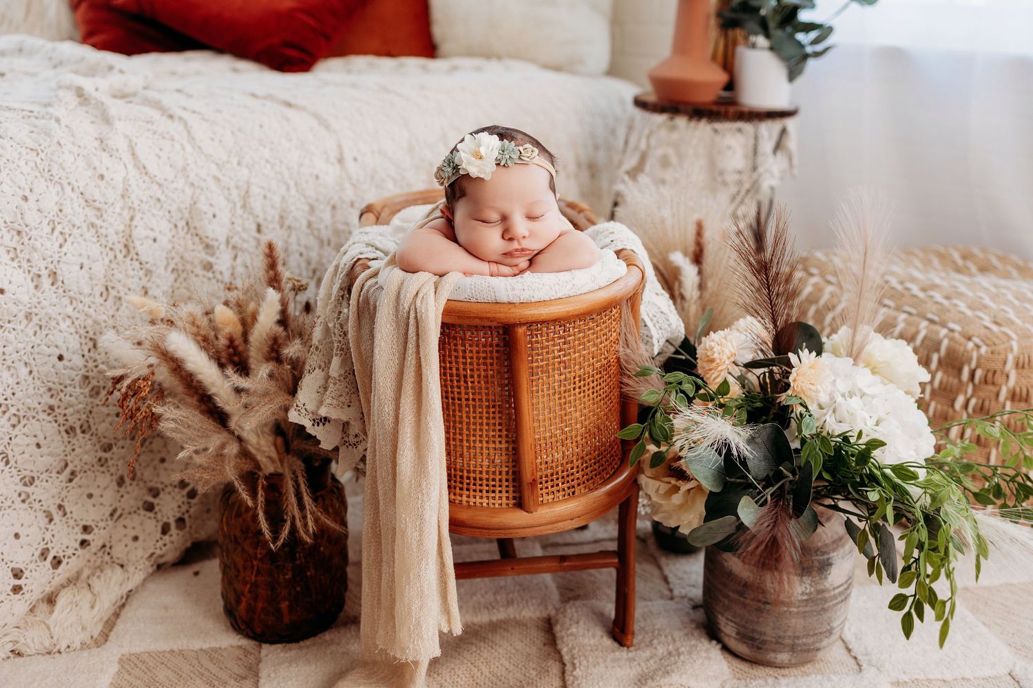Professional newborn photographer capturing a peaceful baby girl portrait in a warm and cozy studio setting