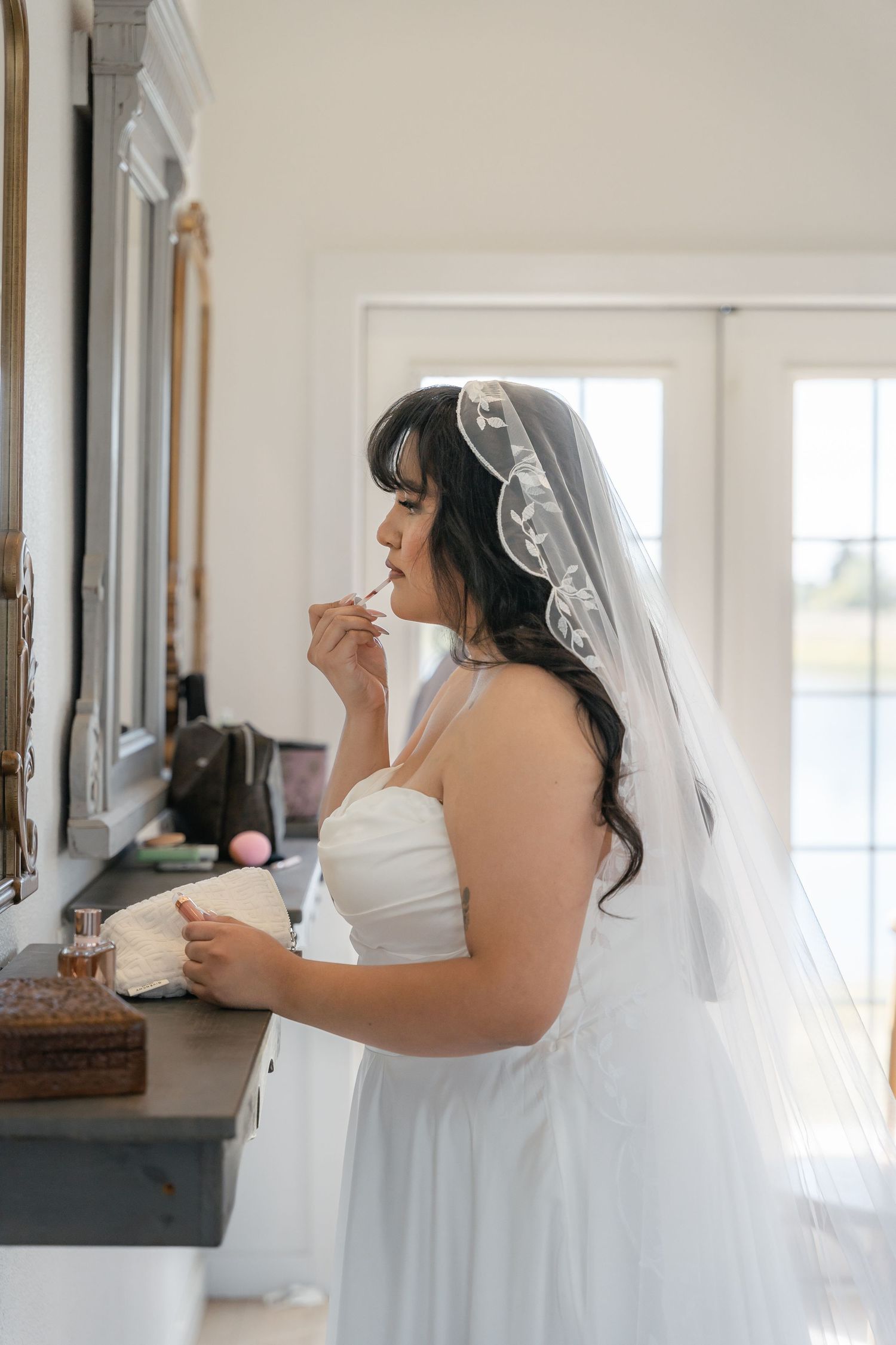 Bride getting ready in a sunlit room for a luxury wedding in Dallas Fort Worth