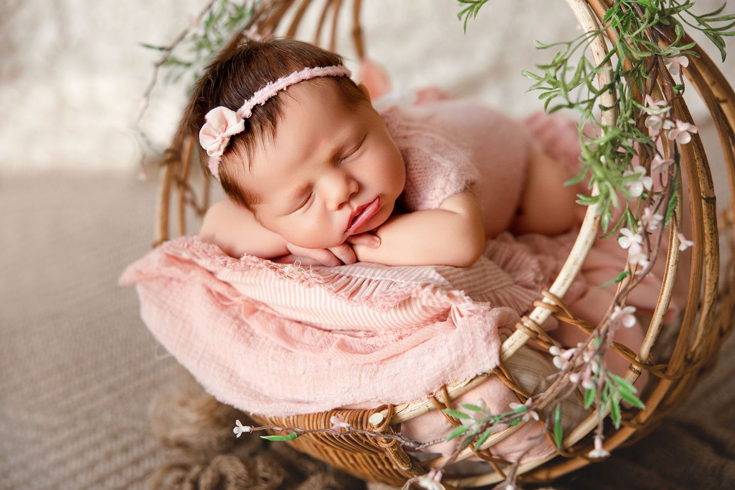 Parents sitting on white bed share tender moments with their newborn baby in a bright, cozy bedroom setting.