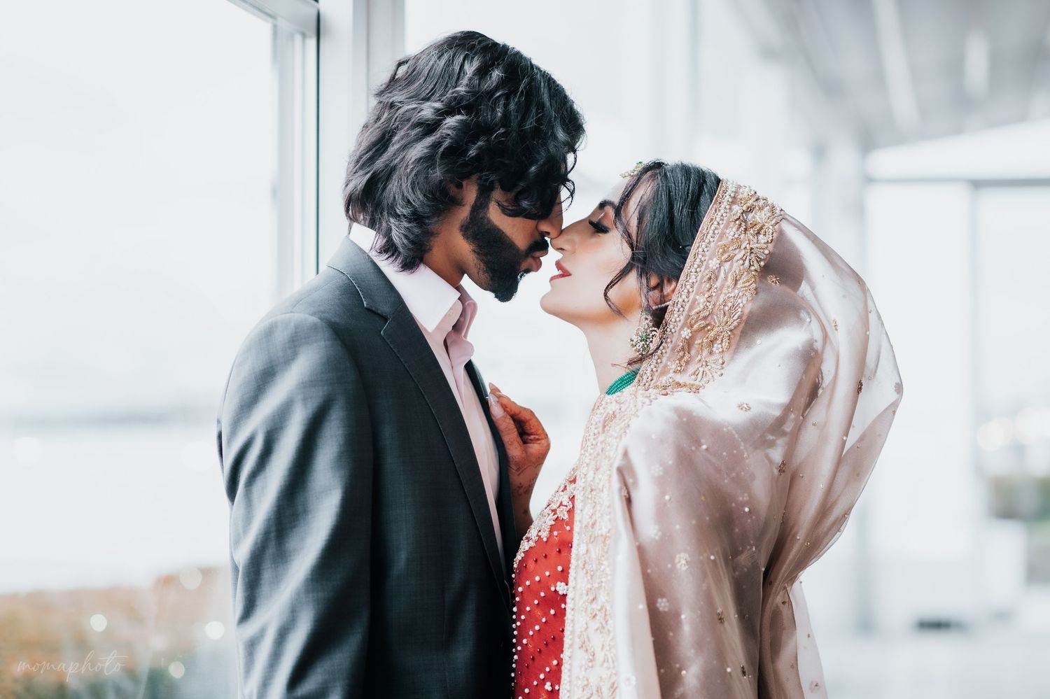 Intimate wedding moment with couple in traditional South Asian attire.