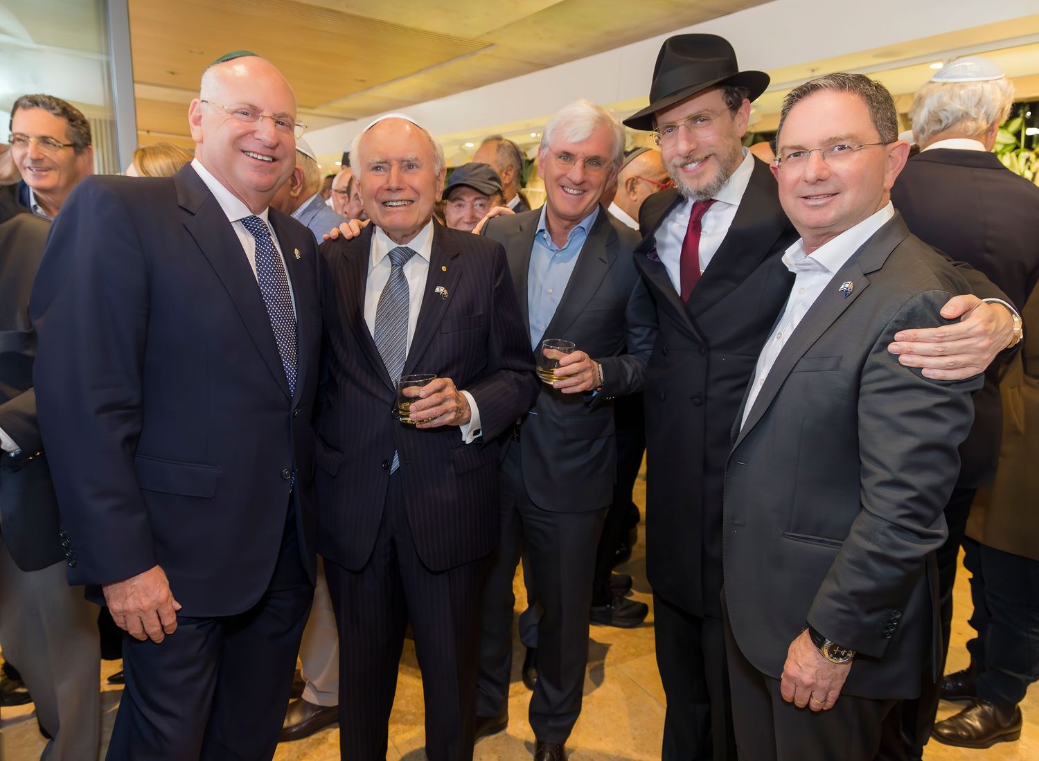 Group of business professionals gather at a networking event in formal attire.