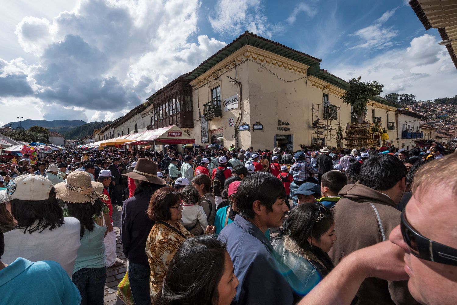 A elevated view of a corner street full of large crowds durning a festival in Cusco Peru.