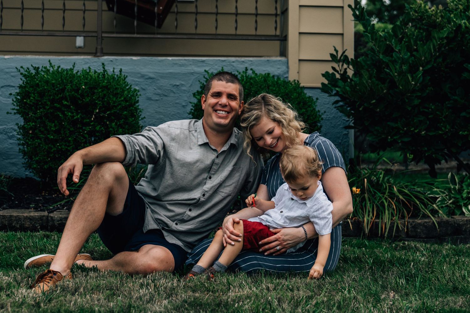 Family enjoying a relaxed moment together on their front lawn.