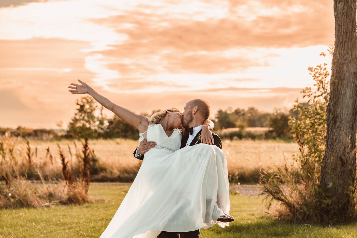 A romantic sunset moment with a flowing white dress in a natural outdoor setting.