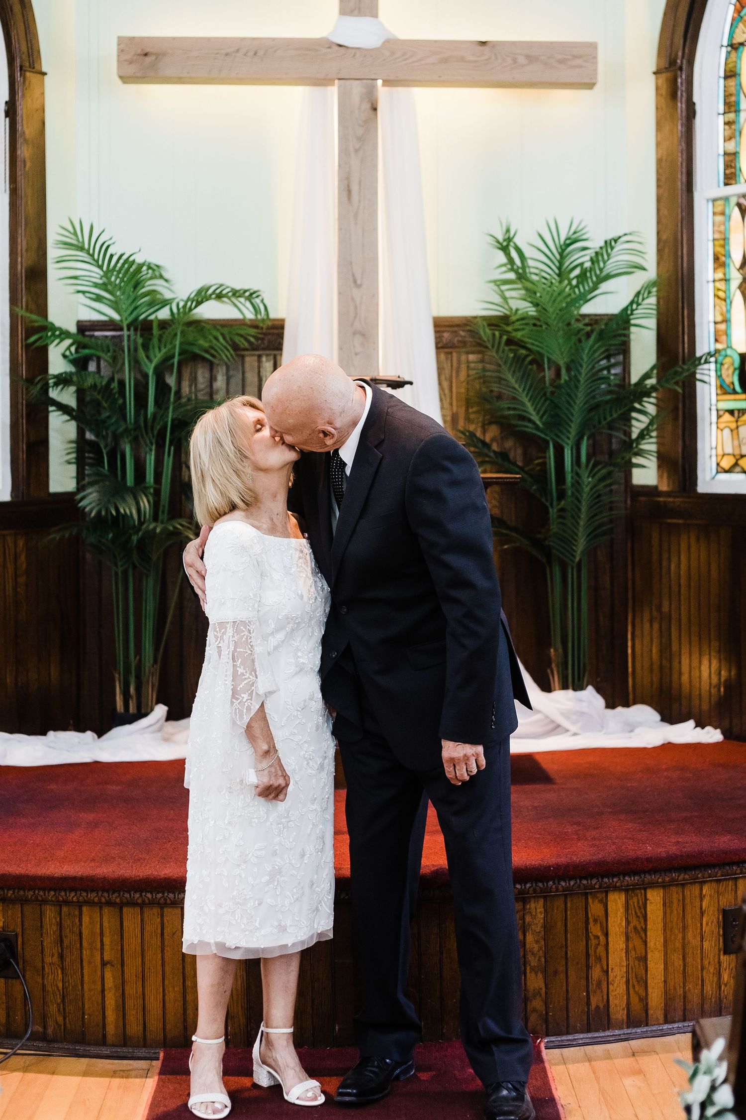 Wedding couple embracing in church sanctuary.