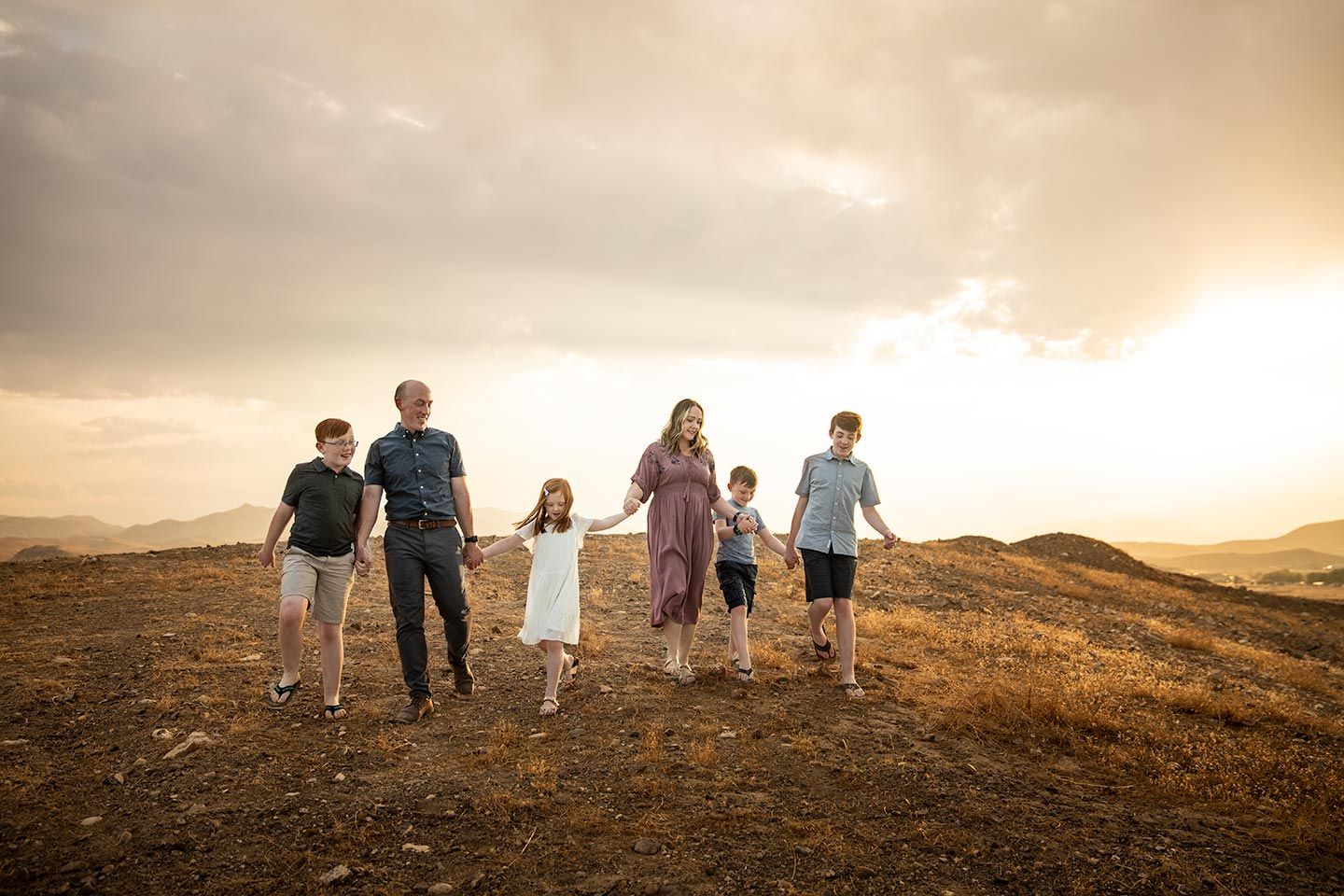 Family holding hands while walking down a desert hill in Nevada