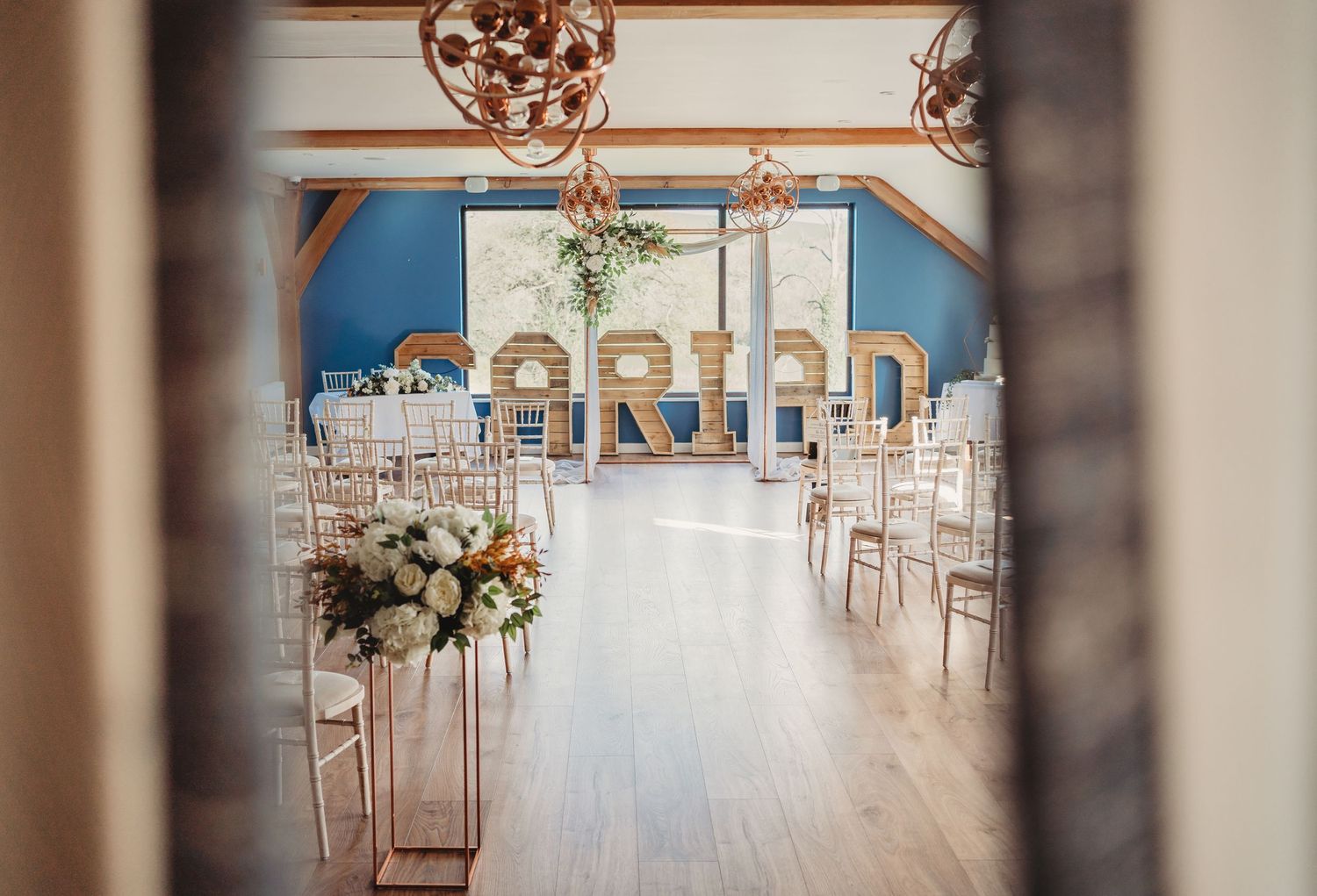 Wedding reception room with the word Cariad in large wooden blocks at the back of the room