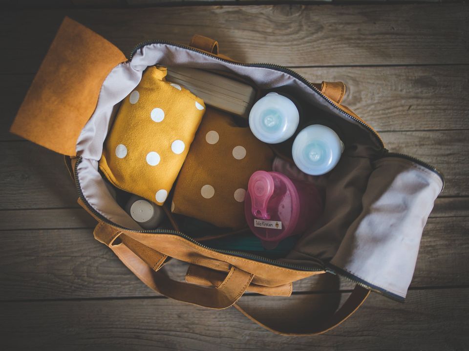 hospital bag leather diaper luggage baby bottle wood background swaddle blanket milk formula tan