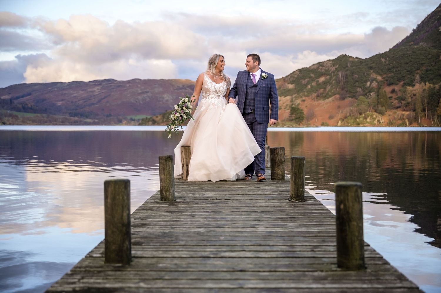 Bride and groom walking along jetty at the Inn on the Lake