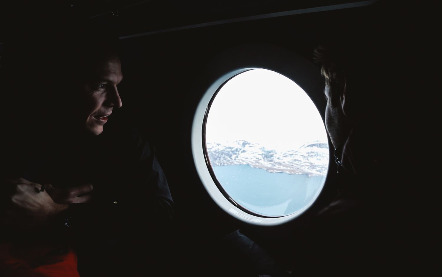 Split Tom and James look out plane window to Greenland