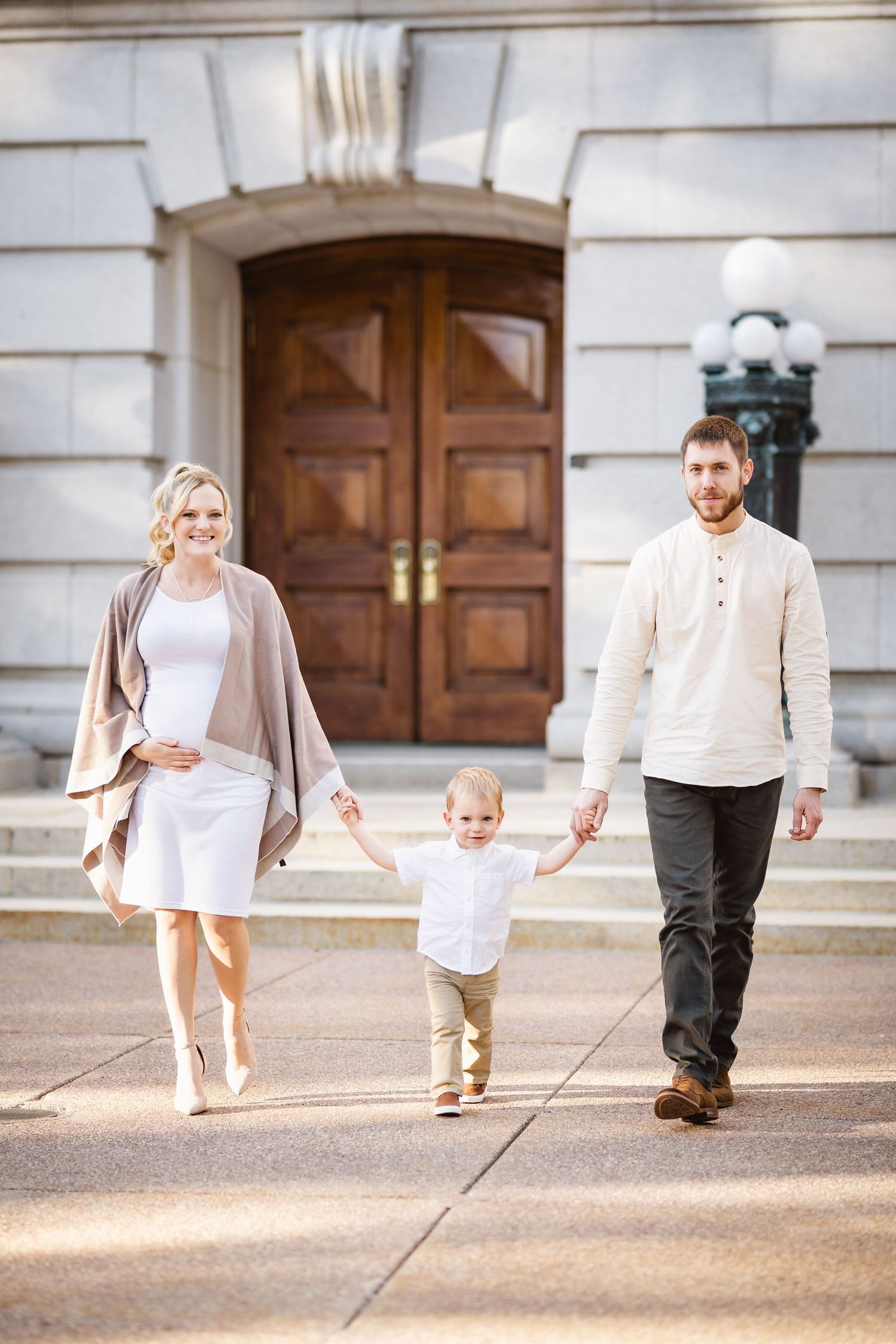 A family of three walking in front of the state capitol building