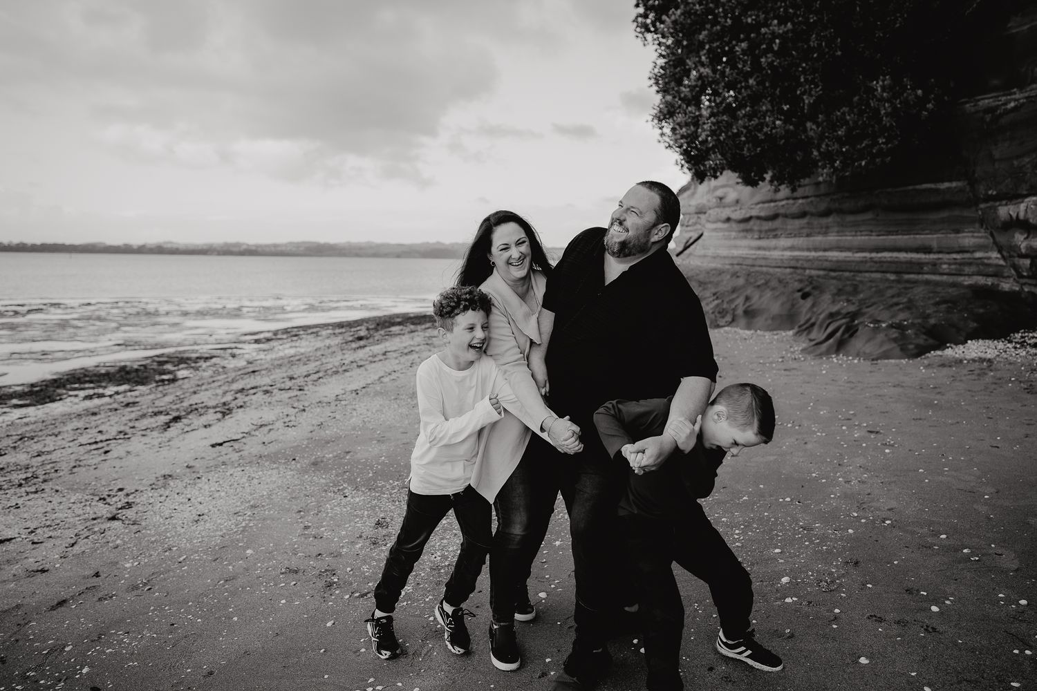 family bumping into each other while walking at the beach