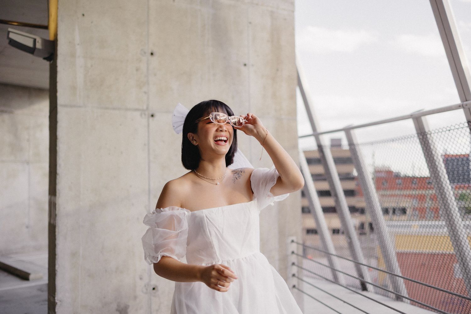 A series of joyful dance movements in a bright urban setting wearing a flowing white dress.
