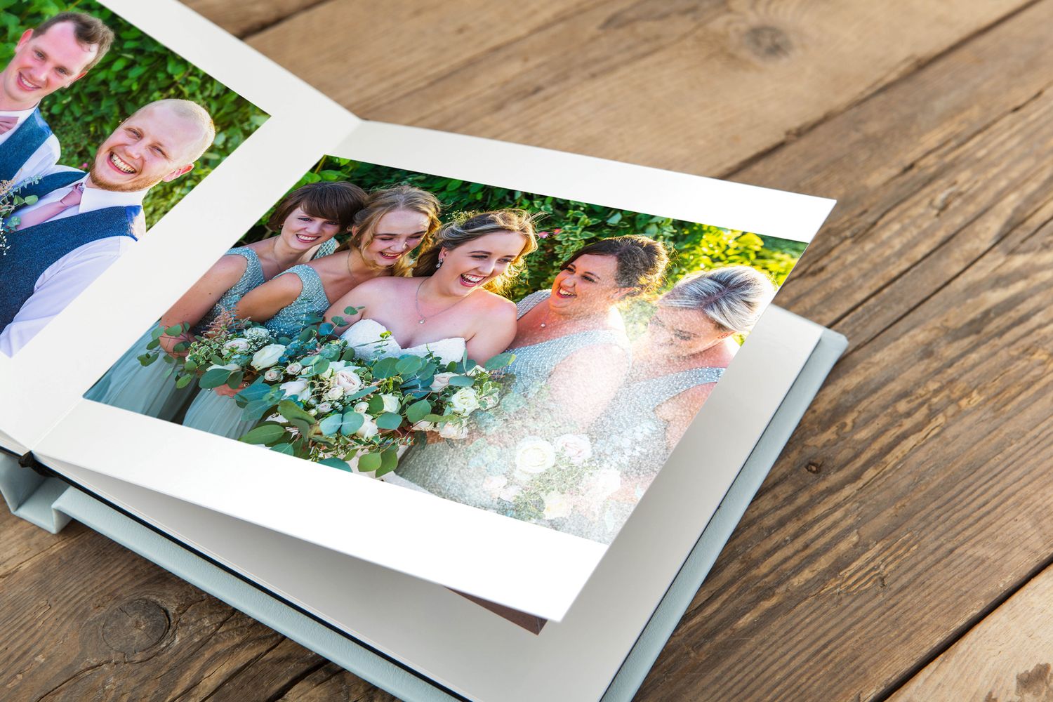 Wedding photo album showing bridal party group shot with vibrant outdoor background.