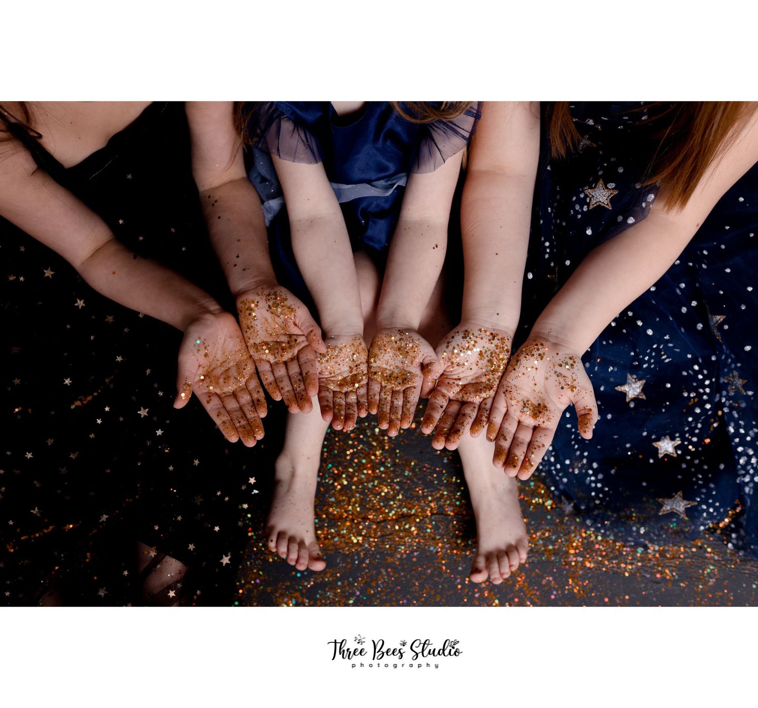 Hands decorated with henna designs displayed against a sparkly dark background.