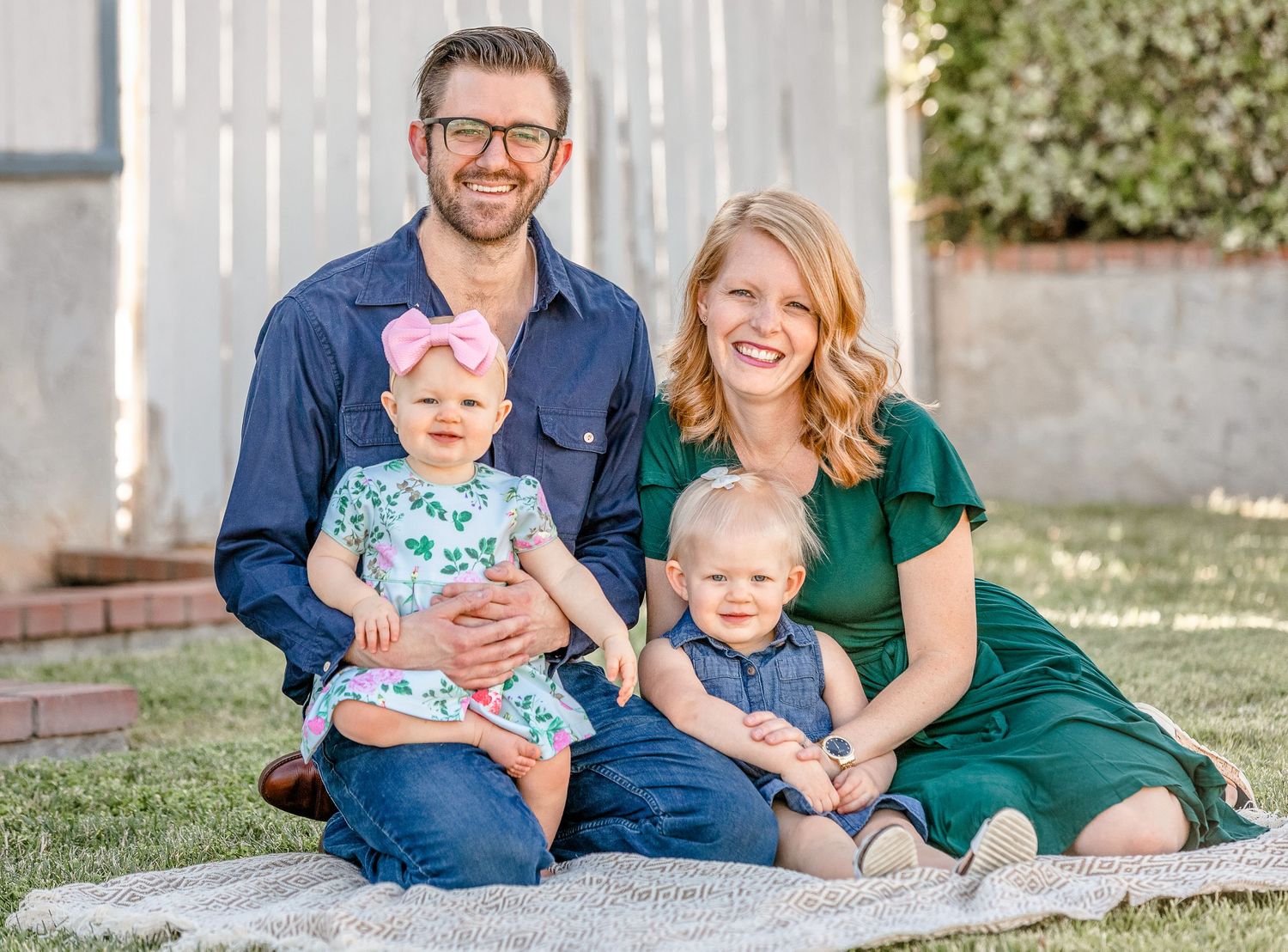Cute young family with two little girls wearing bows