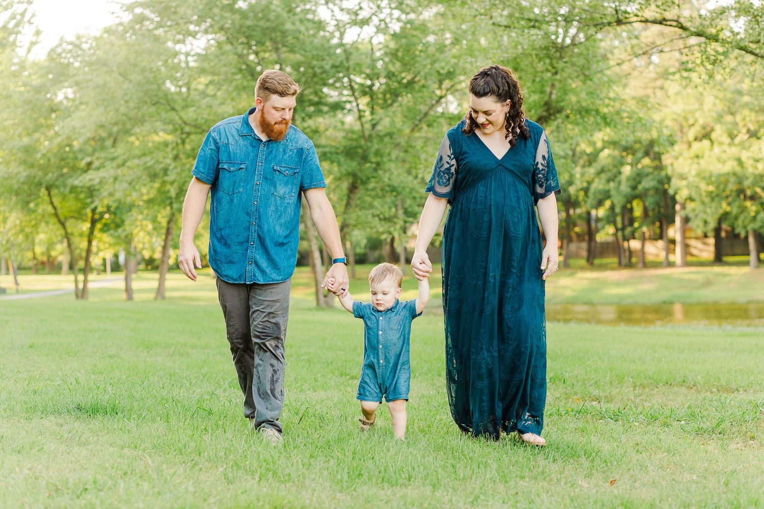 A family taking a stroll together through a peaceful park on a sunny day.