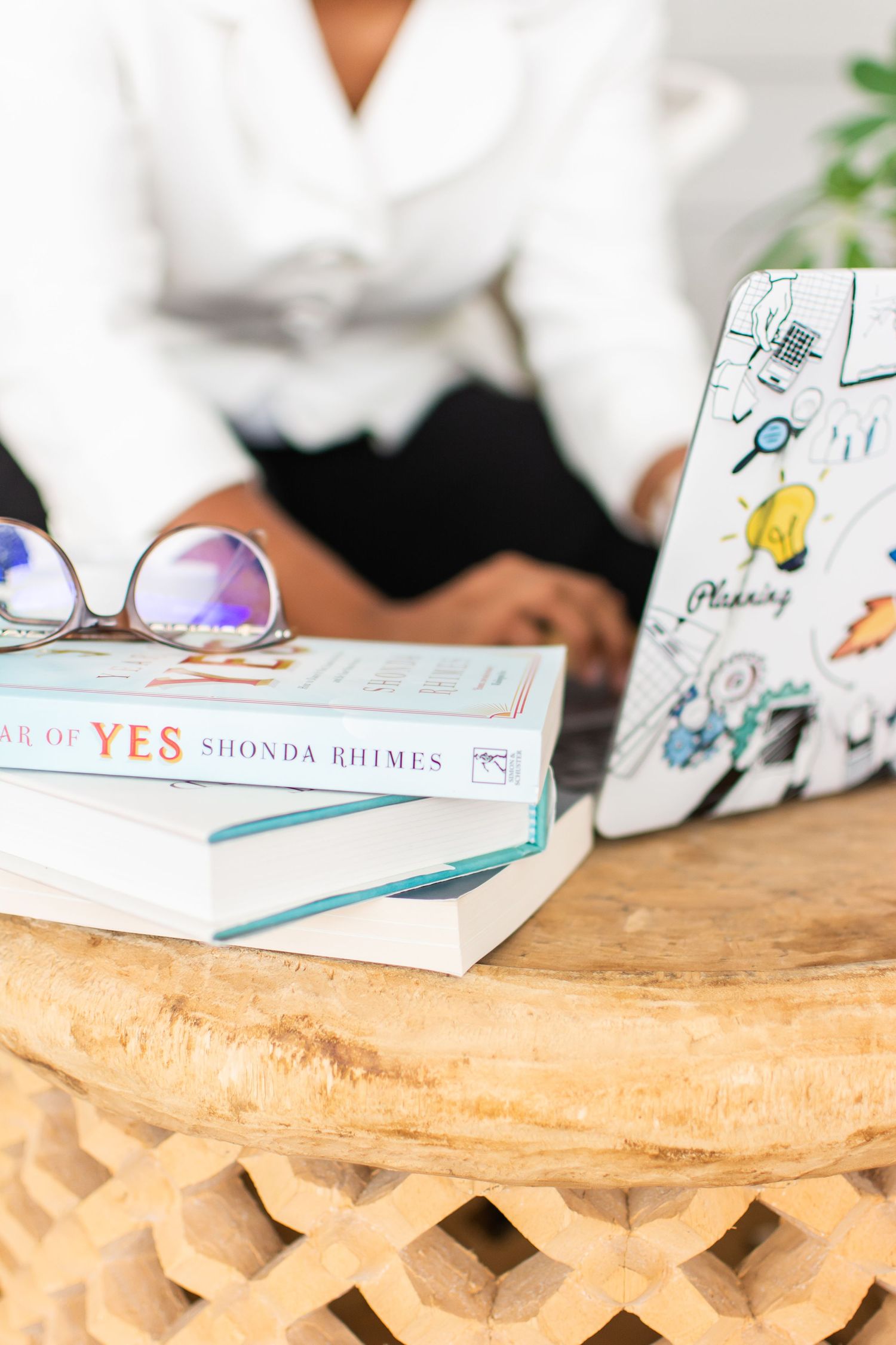 Laptop with books and glasses on a desk