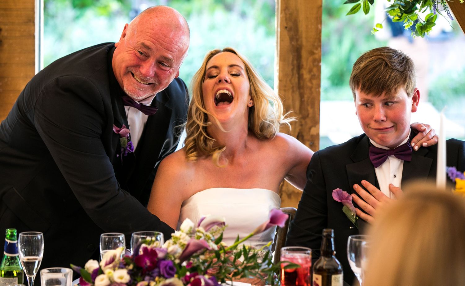 Candid moments of laughter and joy during a wedding reception dinner.
