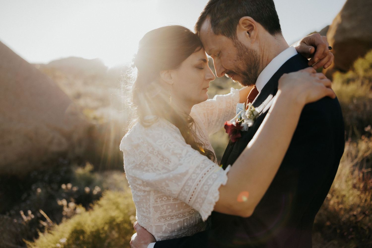 Romantic sunset wedding portrait in mountainous landscape.