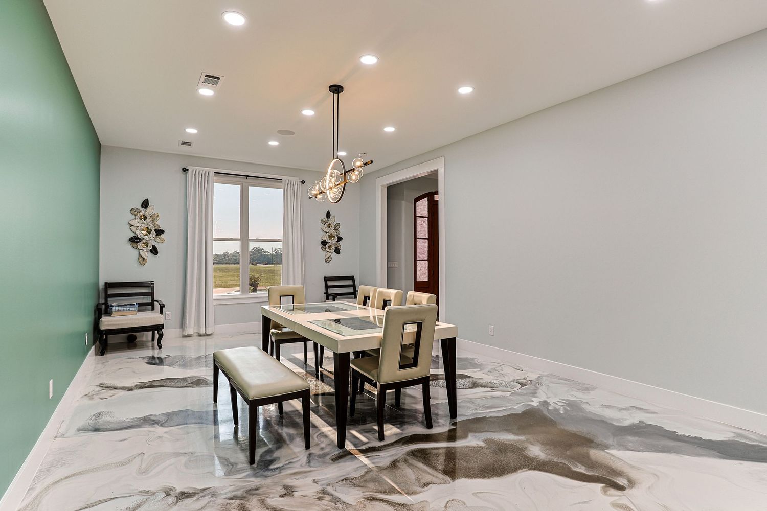 Modern red brick ranch home with attached two-car garage and manicured lawn under blue sky.