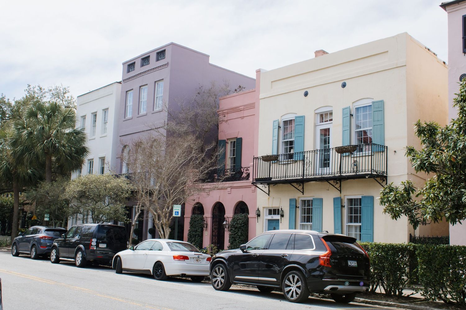 Colorful historic row houses in pastel shades line a street in Charleston's historic Rainbow Row district. Charleston pastel houses shoot