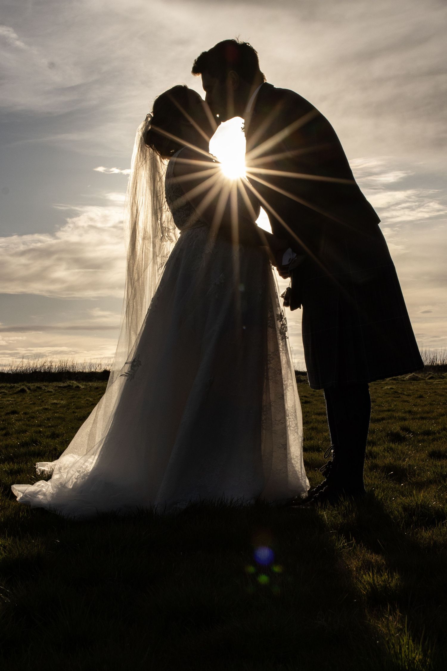 Silhouetted couple in wedding attire against dramatic sunset sky in sequential frames.