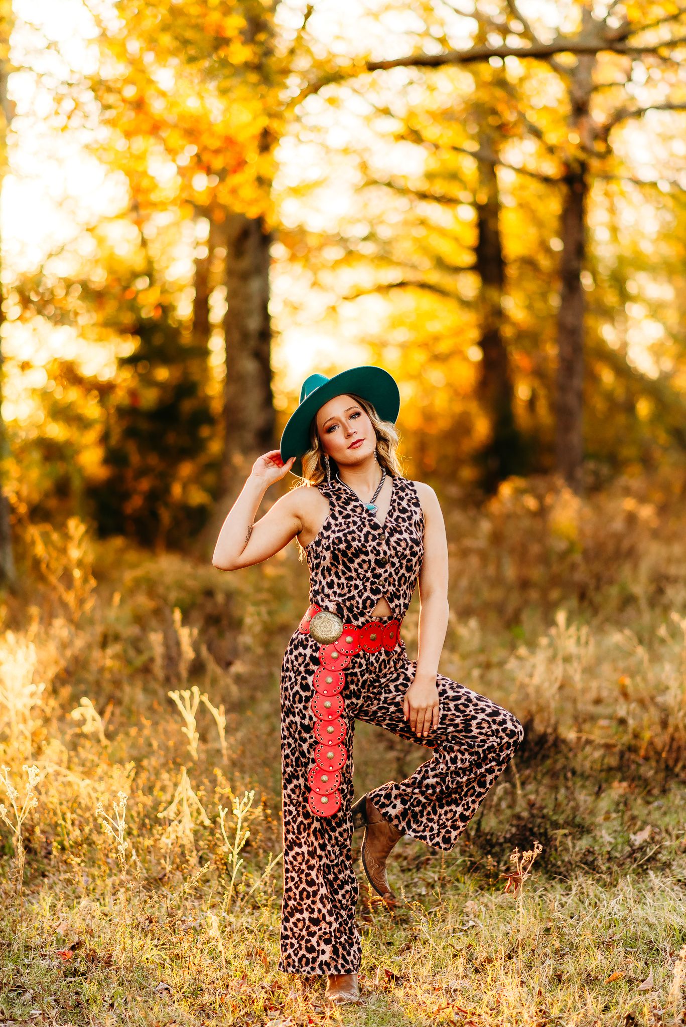 Western style fashion shoot with leopard print dress against fall foliage.