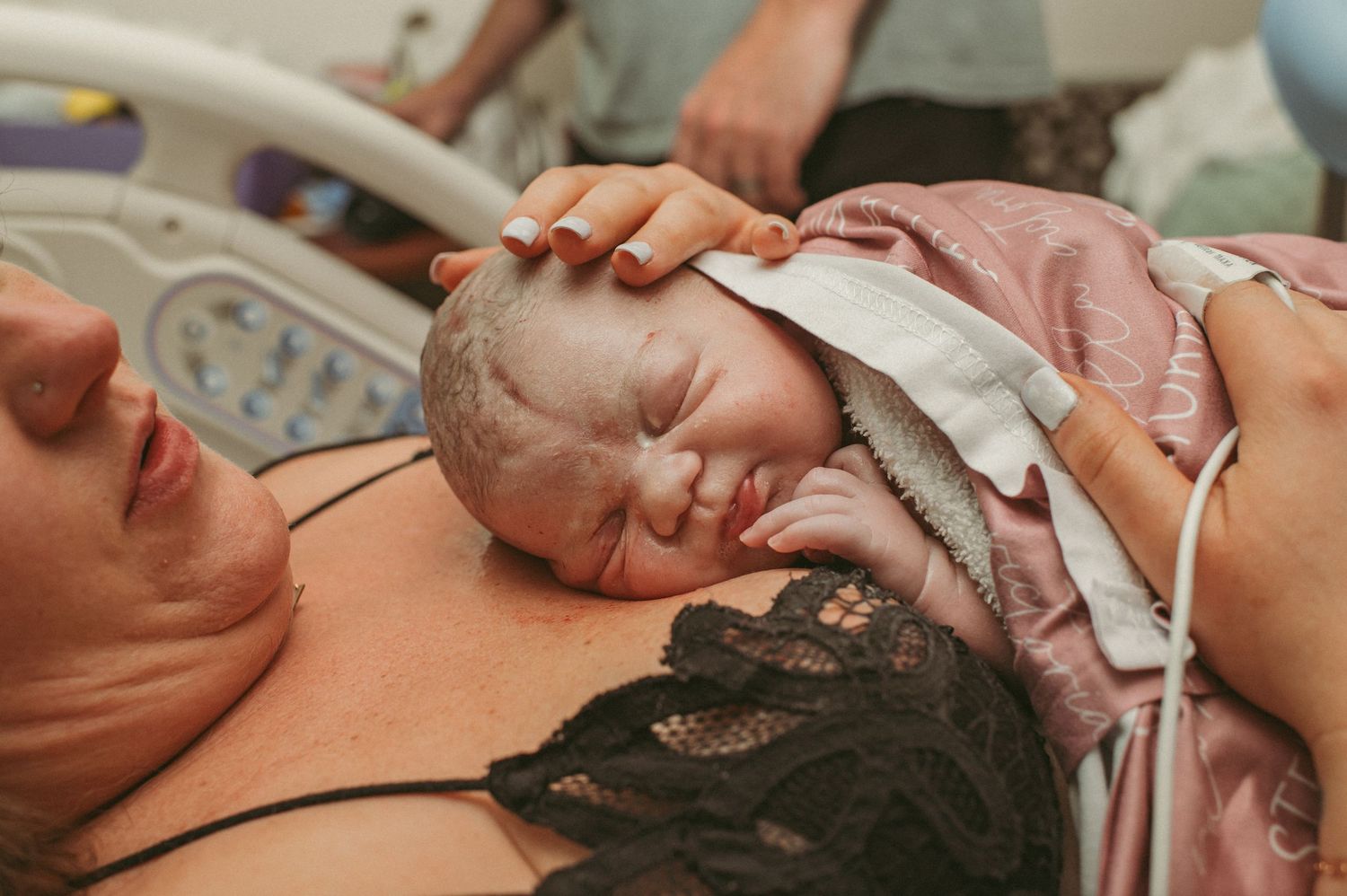 Mom cradles brand new baby girl in the hospital after giving birth to her.