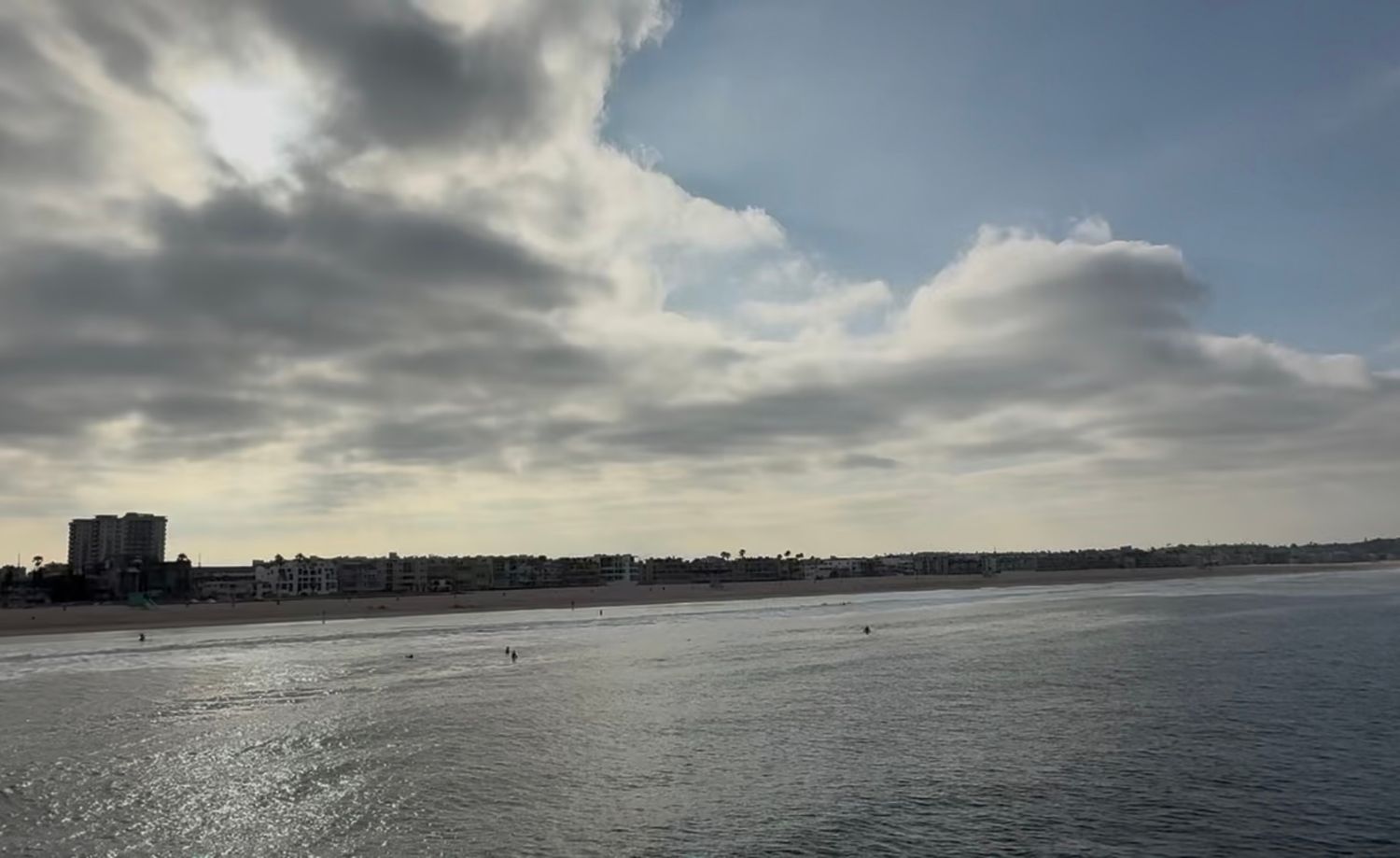 Panoramic waterfront view with clouds reflecting on calm waters.