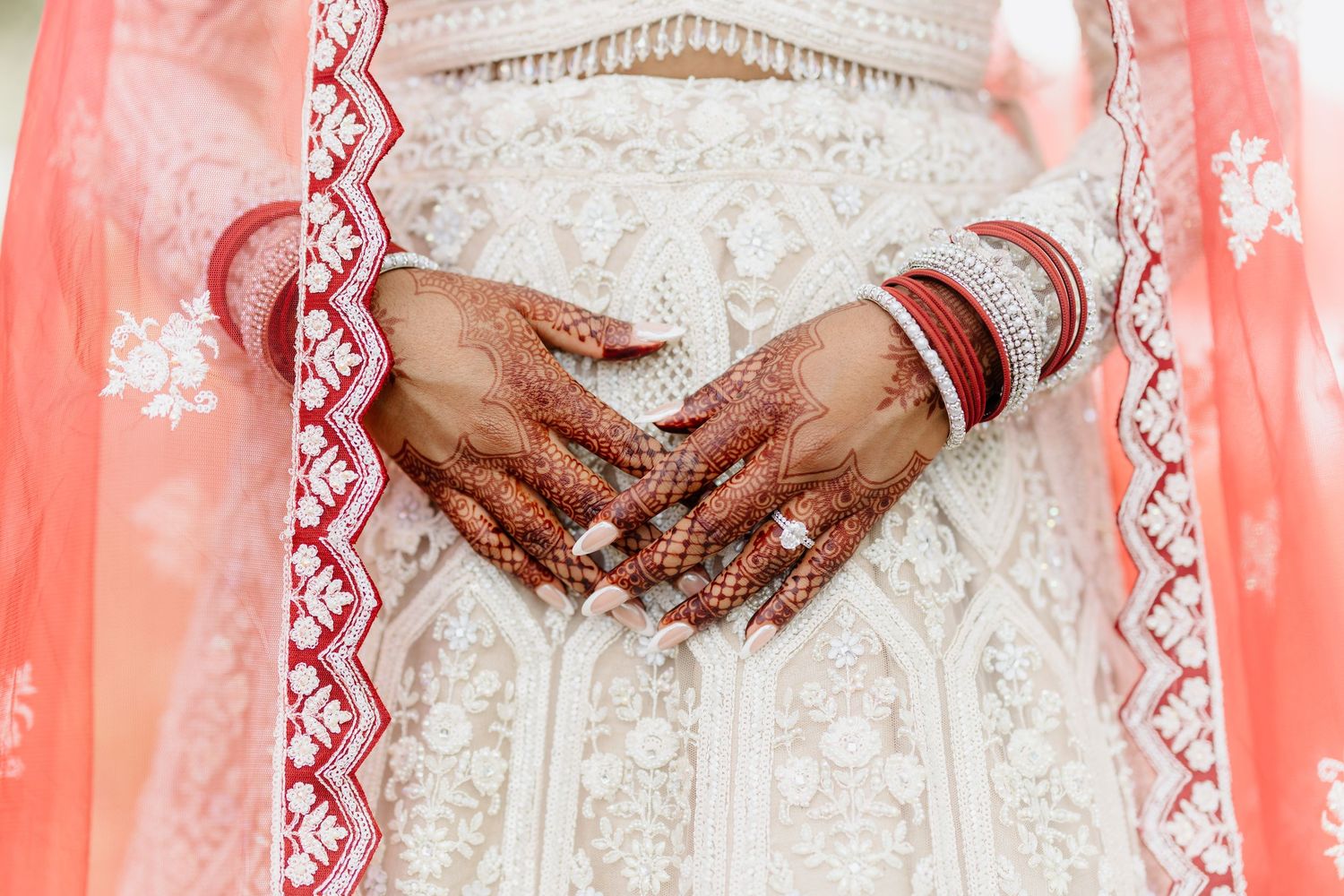 Close-up view of intricate lace details and shimmering beadwork on a white wedding dress.