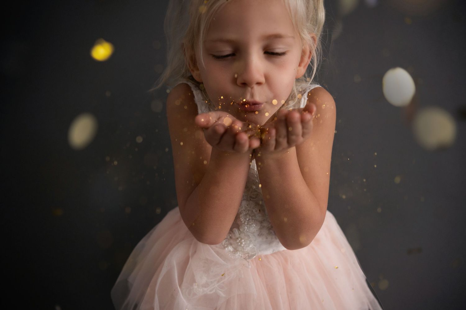 Elegant party dresses and balloons in gold and silver on dark gray background with sparkly confetti details.