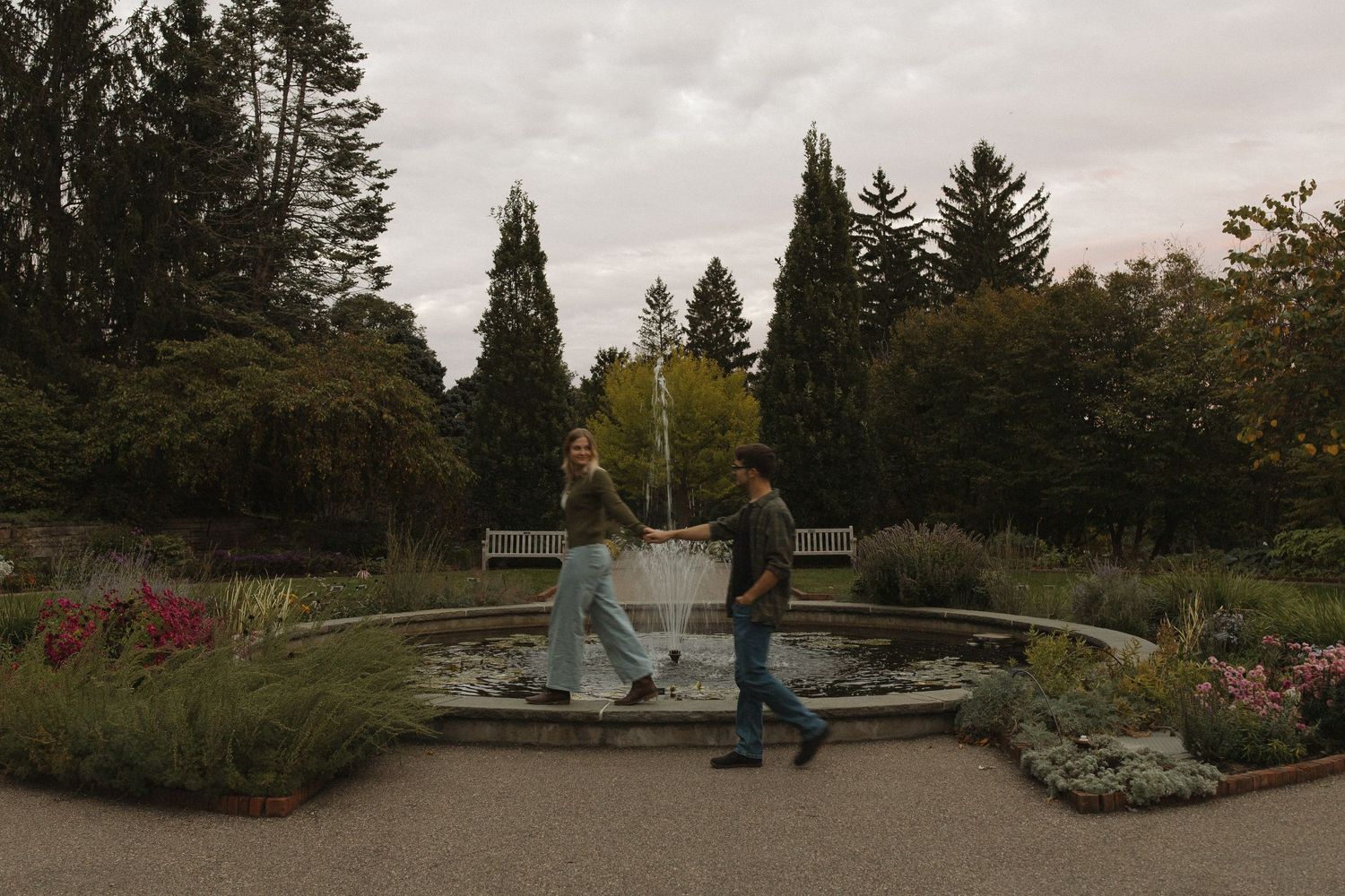 A panoramic view of a peaceful garden park with evergreen trees and walking paths.