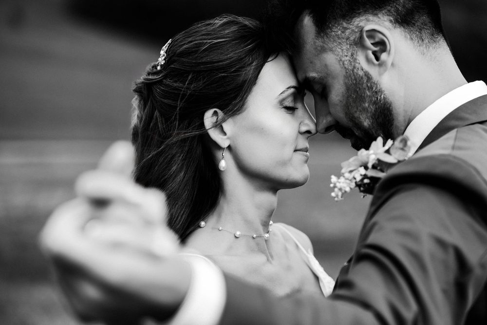 A romantic black and white wedding photo series showing intimate moments between a bride and groom.