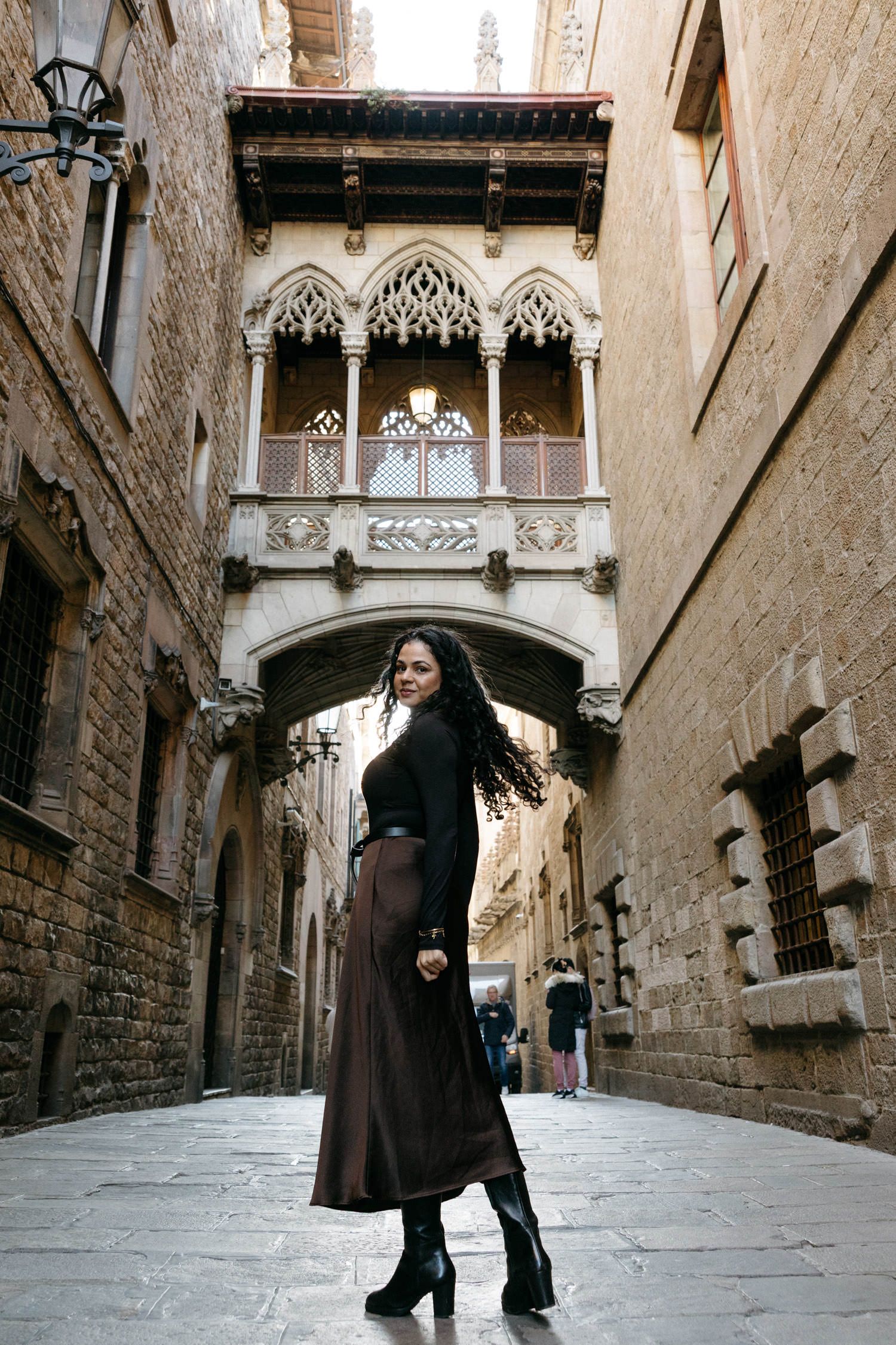 Gothic quarter alleyway with ornate stone bridges and medieval architecture in Barcelona.