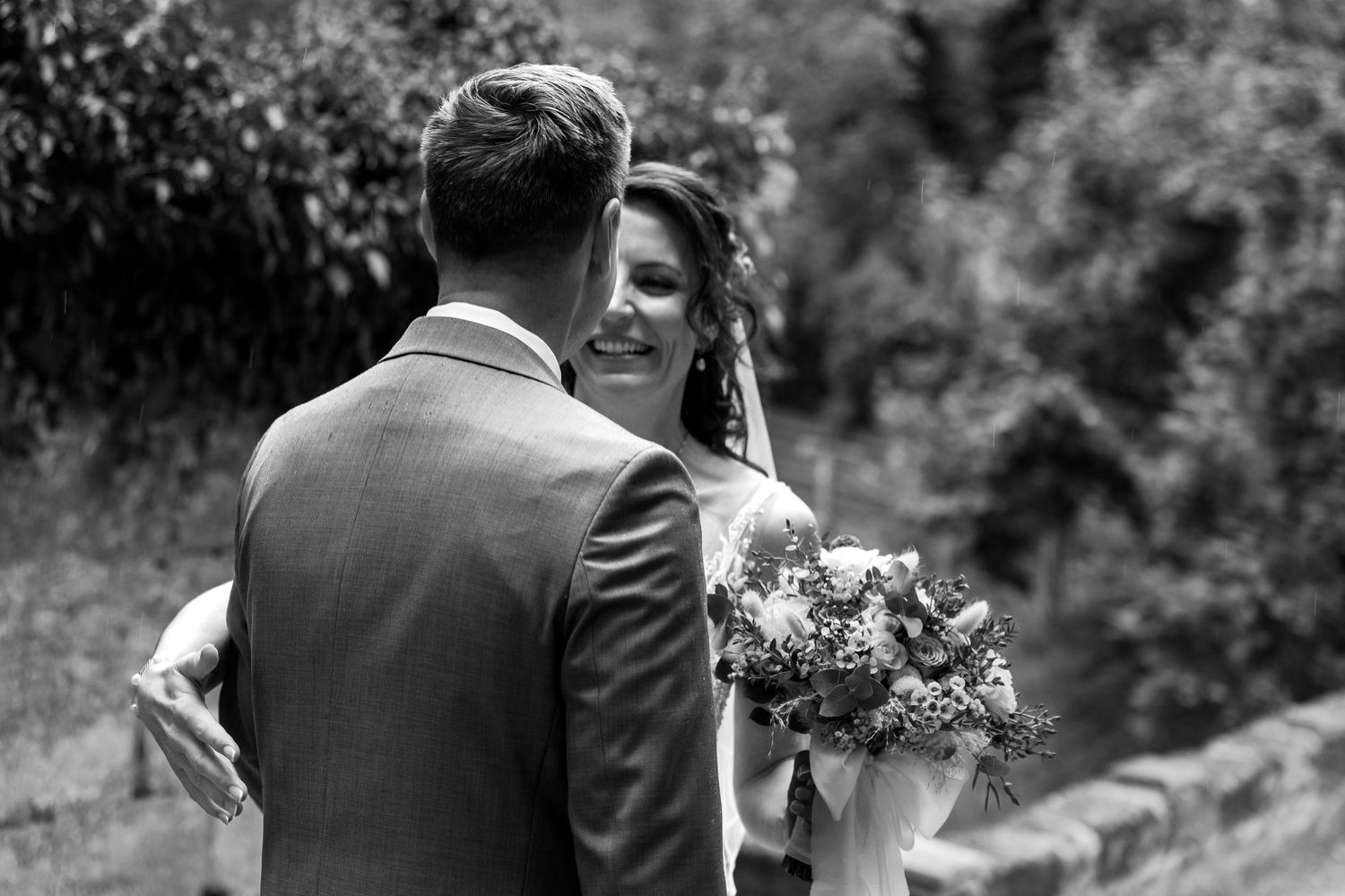 Black and white wedding photos show intimate moments between couples dancing and embracing in an outdoor garden setting.