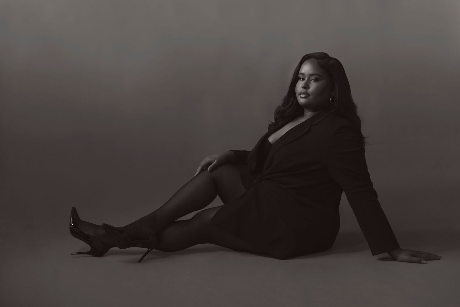 A series of black and white artistic photographs showing a figure reclining in dramatic poses against a dark background.