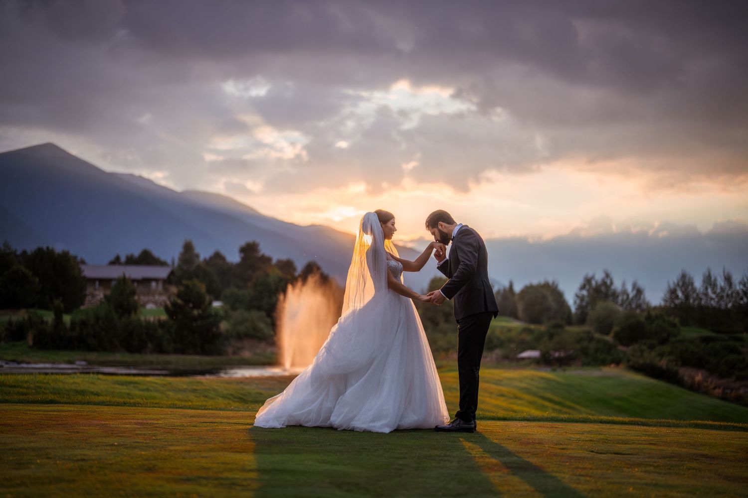 Joyful wedding guests and newlyweds celebrate with raised arms during an outdoor reception ceremony.