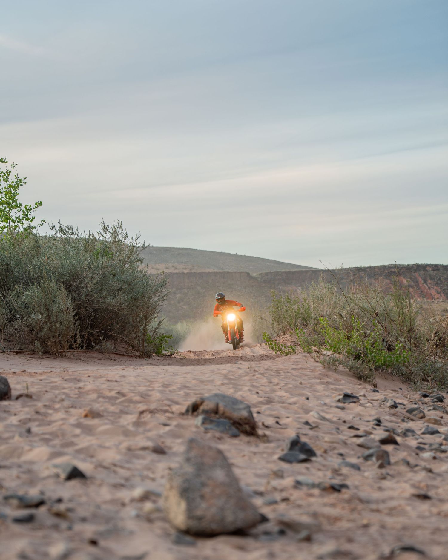 A sequence of desert landscape photos at sunset showing rocks, shrubs, and a glowing lantern on sandy terrain.