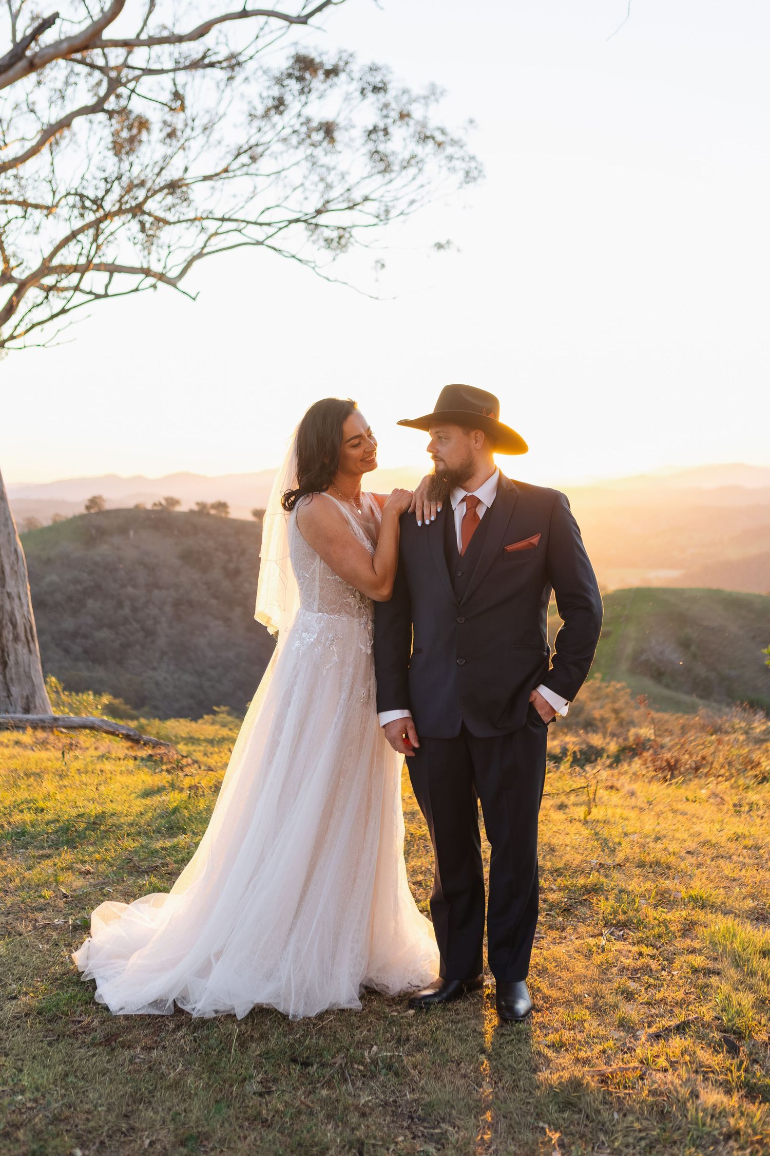 bride and groom looking at eachother on mountain top at sunset at Moonan Cottage wedding