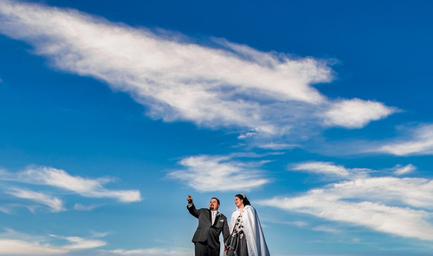 Dramatic blue sky with wispy white clouds stretching across the horizon.