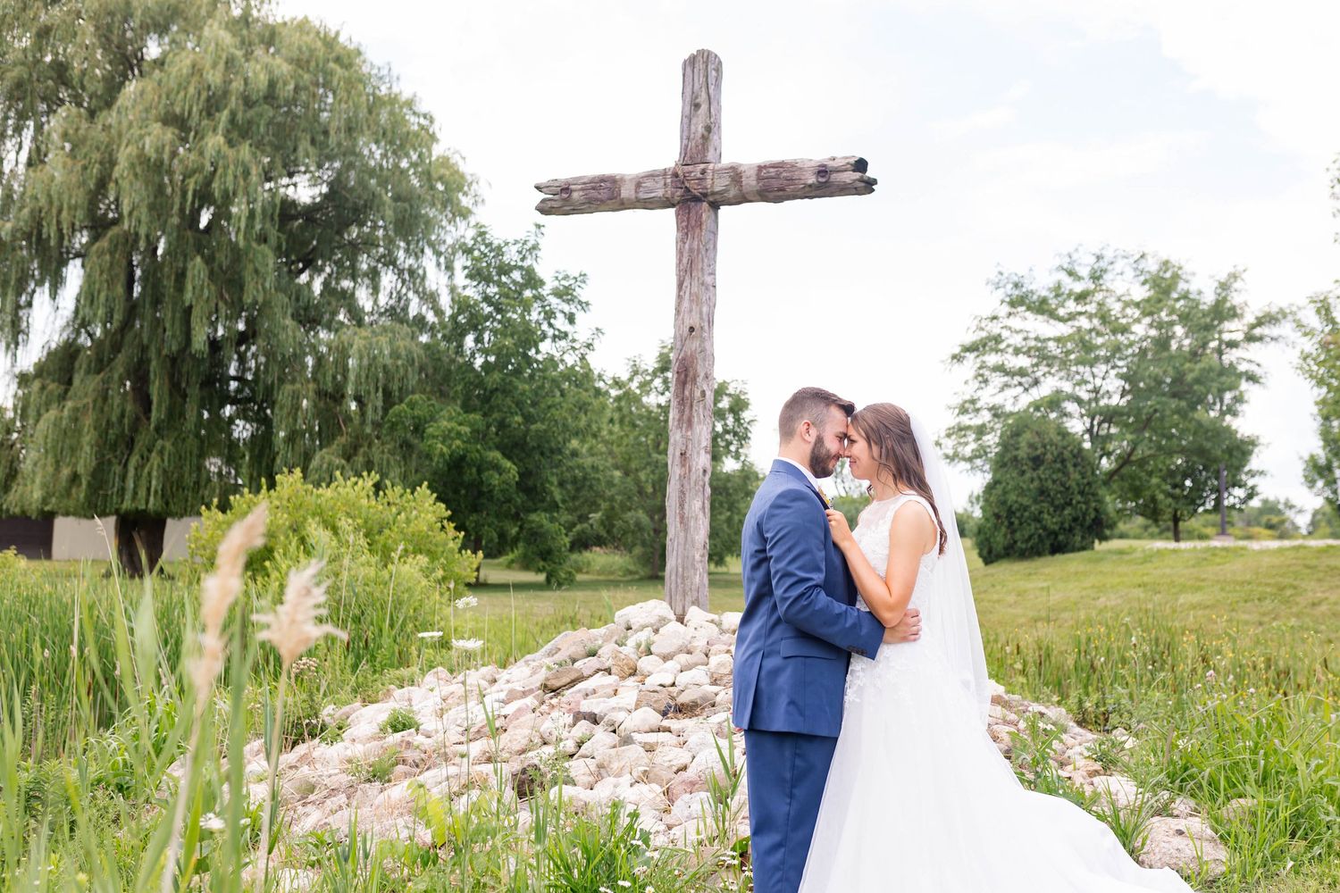 bride and groom with cross in the background