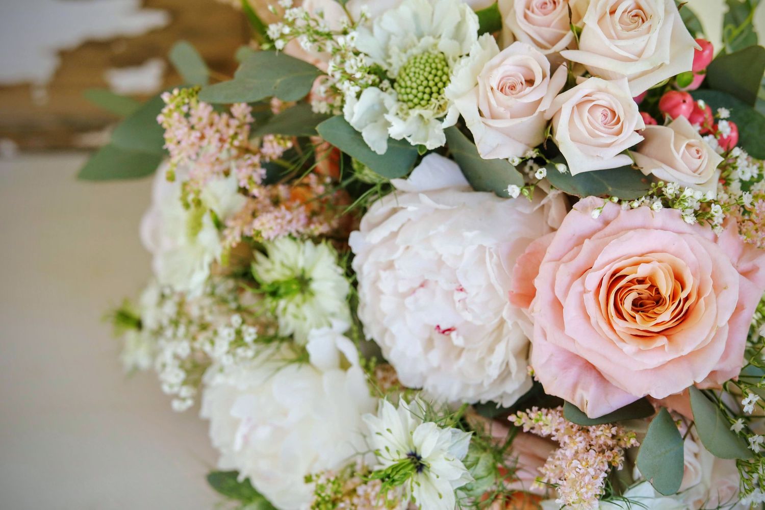 Elegant floral arrangement featuring soft pink roses and white peonies with delicate greenery.