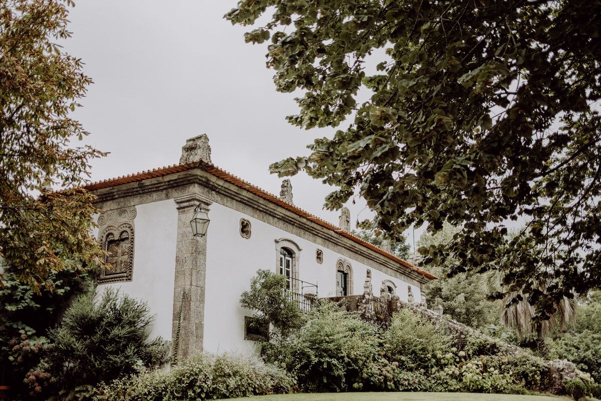 Historic white villa with traditional architecture surrounded by lush gardens.