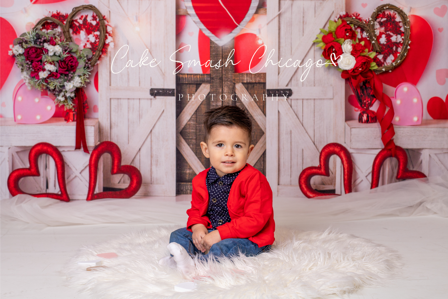 Valentine's Day portrait setup with rustic doors and floral heart wreaths.