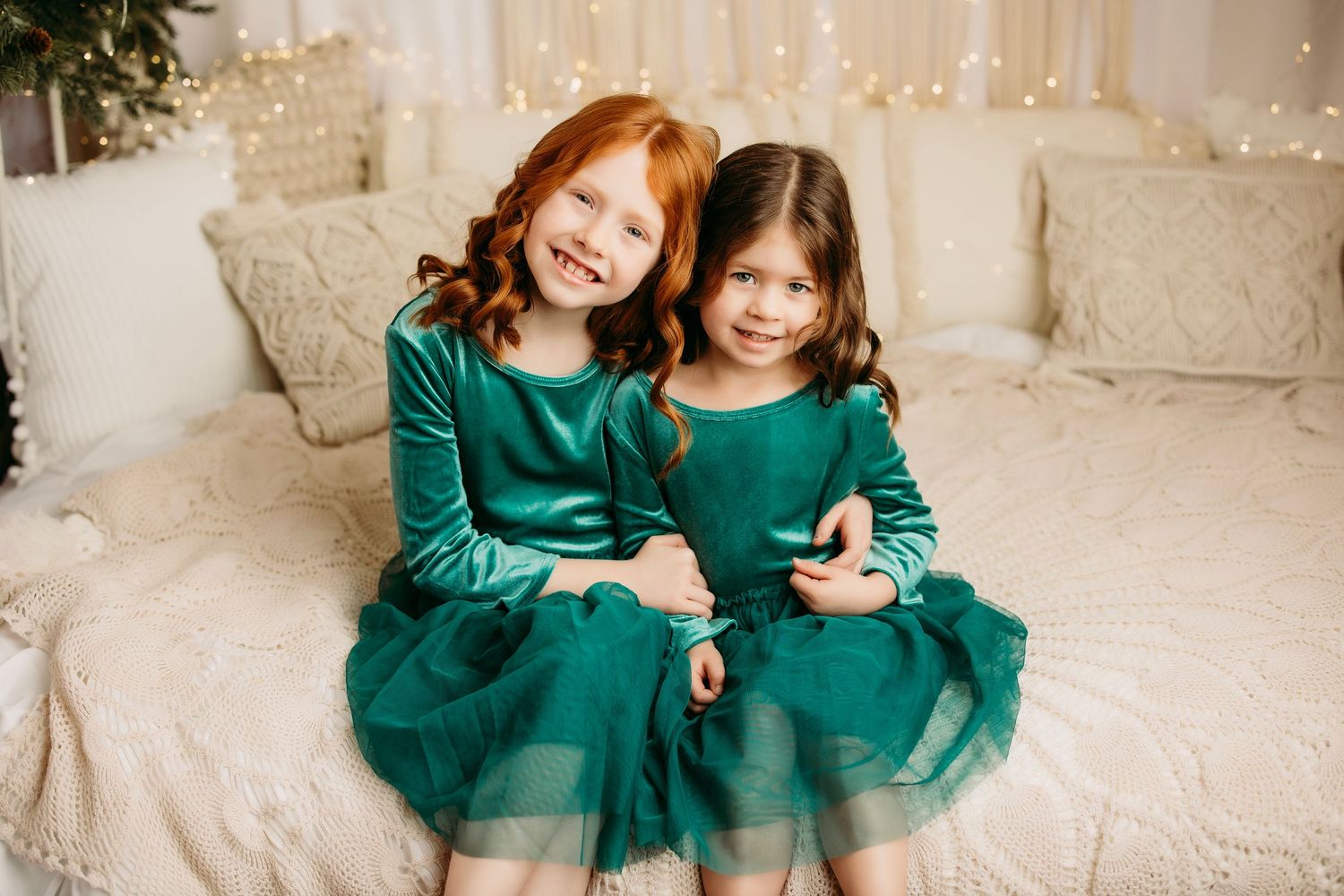 Two people wearing matching emerald green holiday outfits sitting together.