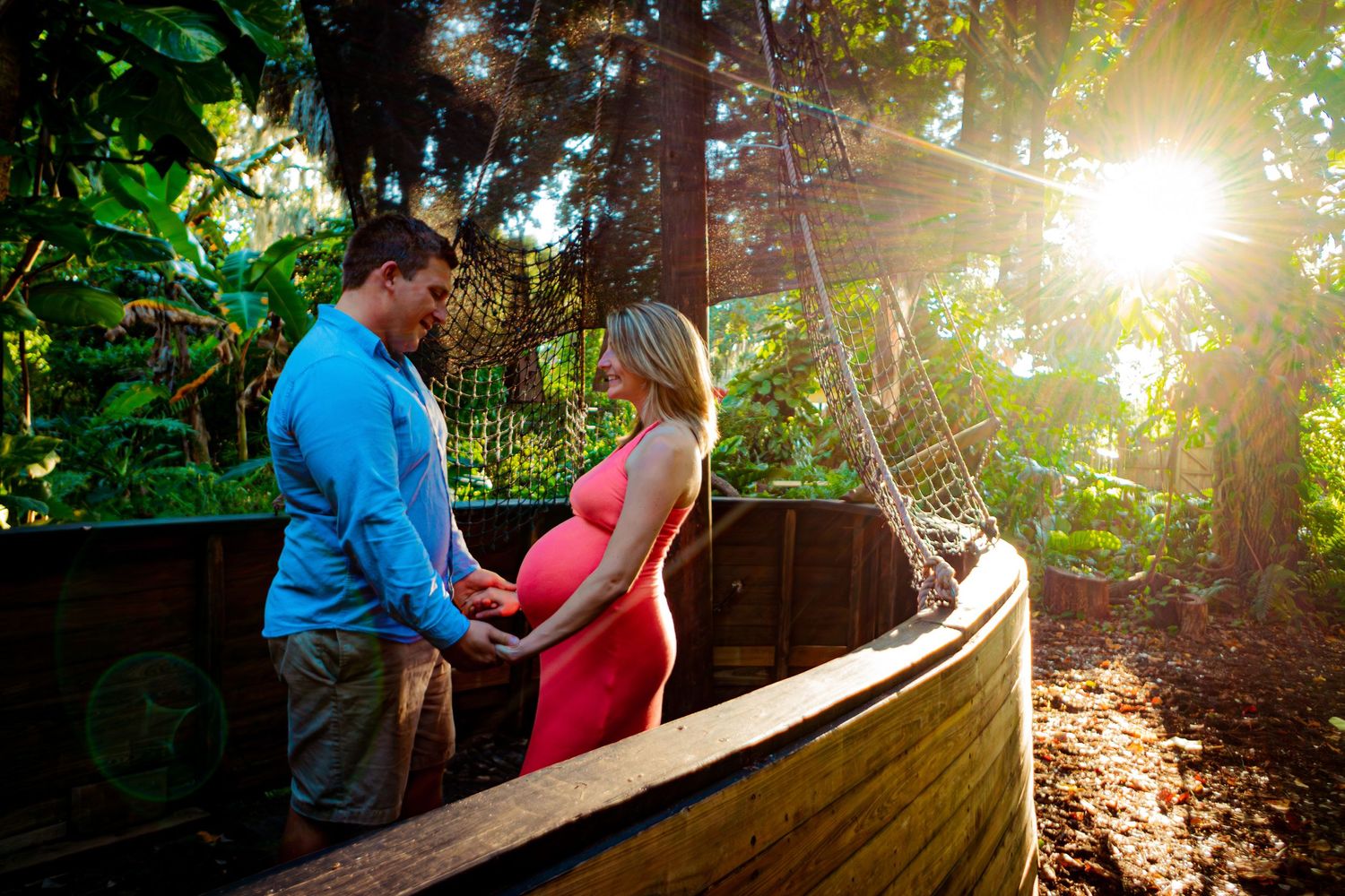 Couple sharing an intimate moment in a wooden boat during golden hour.
